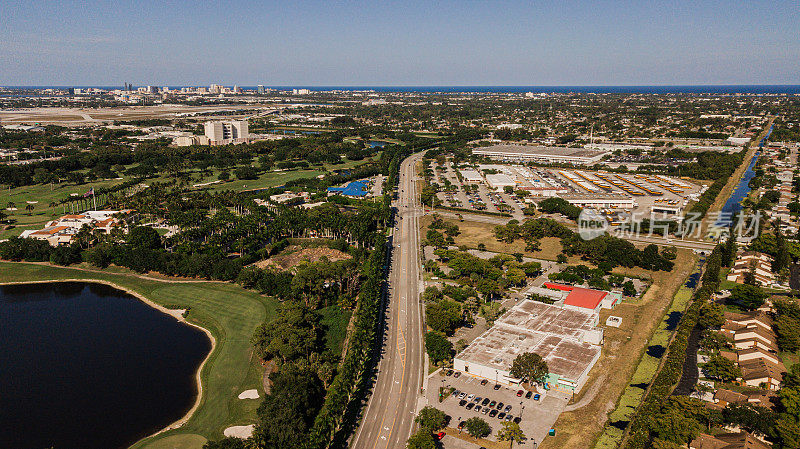 鸟瞰图上的住房，商业建筑和汽车沿着城市街道的Summit Blvd。于2021年4月在佛罗里达州西棕榈滩中部举行